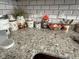 Granite kitchen counter with white subway tile backsplash and decorative vases at 7916 Begonia Ct, Indianapolis, IN 46113