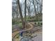 Landscaped backyard garden with winding paths, mature trees, bird feeders, and a seating area at 8224 Claridge Rd, Indianapolis, IN 46260