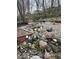Landscaped backyard with a pond, hot tub, water feature, and natural rock details at 8224 Claridge Rd, Indianapolis, IN 46260