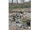 Outdoor pond with decorative rocks, clear water, and lush landscaping, adding a peaceful element to the backyard at 8224 Claridge Rd, Indianapolis, IN 46260