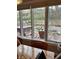 Scenic backyard view from indoors featuring a deck, a pond, mature trees, and lush landscaping at 8224 Claridge Rd, Indianapolis, IN 46260