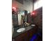 Stylish bathroom with stone walls, double sinks, vanity, and decorative lighting at 8224 Claridge Rd, Indianapolis, IN 46260