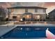 Backyard pool and stone patio with fire pit, perfect for relaxation and outdoor entertaining at 9880 Wading Crane Ave, Fishers, IN 46055