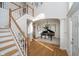 Grand foyer with soaring ceilings, hardwood floors, staircase, and a piano creating an inviting entrance at 9880 Wading Crane Ave, Fishers, IN 46055
