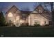 Elegant two-story brick home featuring a manicured lawn and a charming entrance with a blue front door at 9880 Wading Crane Ave, Fishers, IN 46055