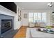 Cozy living room area with a fireplace, built-in cabinets, and natural light from shuttered windows at 9880 Wading Crane Ave, Fishers, IN 46055