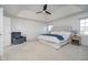 A serene main bedroom with tray ceilings, elegant wall paneling, and a plush chair, creating a relaxing retreat at 9880 Wading Crane Ave, Fishers, IN 46055