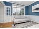 Comfortable home office with a neutral sofa, large window, and French doors for privacy at 9880 Wading Crane Ave, Fishers, IN 46055