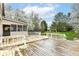 A spacious backyard shows an entertainment deck, play area and mature trees at 10516 Beacon Ln, Indianapolis, IN 46256