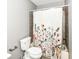 Cozy bathroom with decorative floral shower curtain and a standard toilet at 10516 Beacon Ln, Indianapolis, IN 46256
