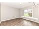 Bedroom with light gray walls, hardwood floors, and window at 10516 Beacon Ln, Indianapolis, IN 46256