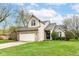 Charming two-story home features a manicured lawn and attached two car garage at 10516 Beacon Ln, Indianapolis, IN 46256