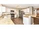 Eat-in kitchen with stainless steel appliances, white cabinets, granite counters, and hardwood floors at 10516 Beacon Ln, Indianapolis, IN 46256