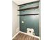 Laundry room with open shelving, dark blue wall, and hardwood floors at 10516 Beacon Ln, Indianapolis, IN 46256