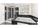 Bathroom showcasing a soaking tub with shower and black tile at 10944 Echo Trl, Indianapolis, IN 46236