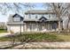 Charming two-story home with brick facade, blue trim, a welcoming front porch, and manicured landscaping at 10944 Echo Trl, Indianapolis, IN 46236