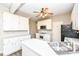 Kitchen boasts white cabinets, modern appliances, a ceiling fan, and ample counter space for meal preparation and dining at 10944 Echo Trl, Indianapolis, IN 46236