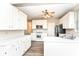 Well-lit kitchen features white cabinets, wood grain floor, ceiling fan, white appliances and plenty of countertop space at 10944 Echo Trl, Indianapolis, IN 46236