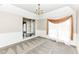 Bright living room featuring neutral walls, plush carpet, and a large window with elegant curtains at 10944 Echo Trl, Indianapolis, IN 46236