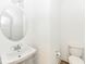 This modern bathroom features a pedestal sink and toilet on wood-look floors at 11392 Gammel Pl, Fishers, IN 46040