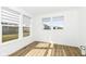 Well-lit bedroom featuring hardwood floors and multiple windows offering serene views of the surrounding neighborhood at 11392 Gammel Pl, Fishers, IN 46040