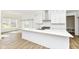 Bright kitchen featuring a large island, white cabinets, subway tile backsplash, and a sliding barn door at 11392 Gammel Pl, Fishers, IN 46040