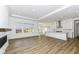 Open-concept living area flows into the kitchen with wood floors, white cabinets, and large windows at 11392 Gammel Pl, Fishers, IN 46040