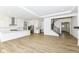 Bright, open living space with hardwood floors flows into modern kitchen with white cabinets and stainless appliances at 11392 Gammel Pl, Fishers, IN 46040