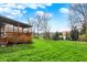 Well-maintained backyard featuring a large grassy area with mature trees and an expansive wooden deck at 11551 Buckskin Dr, Zionsville, IN 46077
