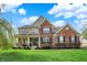 Charming two-story brick home with landscaped front yard and inviting porch, perfect for curb appeal at 11551 Buckskin Dr, Zionsville, IN 46077