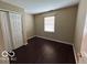 A clean bedroom with light beige walls, closet, and dark wood flooring at 11876 Wapiti Way, Noblesville, IN 46060