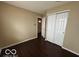 A simple bedroom with a closet featuring white paneled doors and dark wood flooring at 11876 Wapiti Way, Noblesville, IN 46060