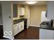 Kitchen with hardwood floors, stainless steel sink, white cabinets, and a view to living area at 11876 Wapiti Way, Noblesville, IN 46060