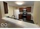 Cozy kitchen featuring dark wood cabinets and stainless steel appliances at 11876 Wapiti Way, Noblesville, IN 46060