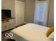 Bedroom with white bedding, soft natural light, and a charming accent cabinet at 1216 N Holmes Ave, Indianapolis, IN 46222