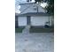 View of the home's rear showing gravel parking, air conditioner, siding, stairs, and dark-colored door at 1216 N Holmes Ave, Indianapolis, IN 46222