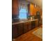 Cozy kitchen featuring dark wood cabinets, updated appliances, and a window with star-patterned curtains at 13124 S Elster Way, Fishers, IN 46037