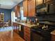 Functional kitchen featuring wood cabinetry, black appliances, and hardwood floors at 13124 S Elster Way, Fishers, IN 46037