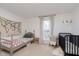 Neutral-toned bedroom with a twin bed, a crib, and a window that brings natural light and a calming vibe at 1407 Hannibal St, Noblesville, IN 46060