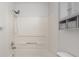 Bathroom with shower-tub combo with white tiling and open shelving for storage at 1512 Tipton Ln, Columbus, IN 47201