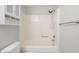 Bathroom with a shower-tub combo with white tiling, storage, and a toilet at 1512 Tipton Ln, Columbus, IN 47201