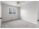 This bedroom features neutral walls and carpet, a ceiling fan, and natural light at 1512 Tipton Ln, Columbus, IN 47201
