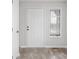 Entryway featuring a six-panel front door, wood-look flooring, a window with blinds, and light gray paint at 1512 Tipton Ln, Columbus, IN 47201