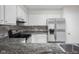 Updated kitchen features stainless steel refrigerator, tile backsplash and granite countertops at 1512 Tipton Ln, Columbus, IN 47201