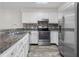 Bright kitchen with stainless steel appliances, white cabinets, dark countertops, and wood-look flooring at 1512 Tipton Ln, Columbus, IN 47201