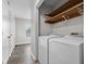 Bright laundry area featuring modern washer and dryer units with convenient storage shelves, and hardwood flooring at 1512 Tipton Ln, Columbus, IN 47201