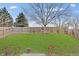 Well-maintained backyard with lush green grass and mature trees, fenced for privacy at 15433 Wandering Way, Noblesville, IN 46060