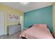 Bright bedroom featuring yellow walls, an aqua accent wall, and a dresser at 15433 Wandering Way, Noblesville, IN 46060