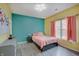 Bright bedroom featuring yellow walls, an aqua accent wall, and ample natural light at 15433 Wandering Way, Noblesville, IN 46060