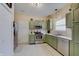 Well-lit kitchen featuring stainless steel appliances and charming green cabinets at 15433 Wandering Way, Noblesville, IN 46060